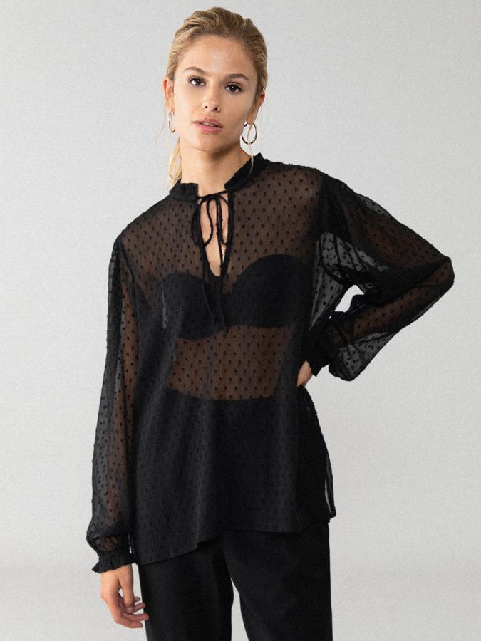 Con mangas largas y escote en forma de pico con lazada a tono, esta blusa plumeti en tejido vaporoso y color negro tiene un precio de 12,99 euros y en la web solo queda en la talla L.