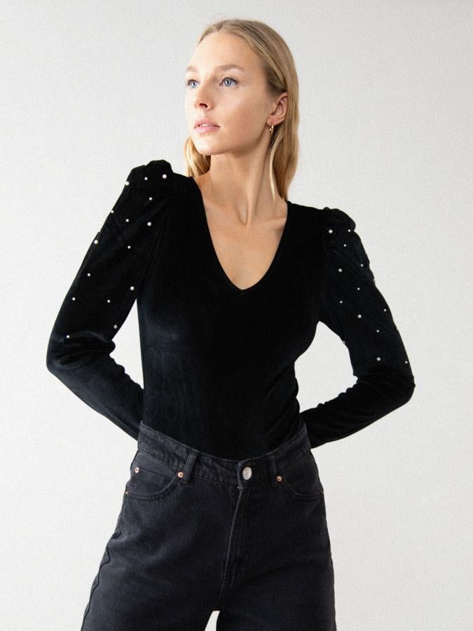 En color negro, este body de manga larga y escote de pico está confeccionado en un tejido elástico de terciopelo con mangas abullonadas adornadas con perlas. Disponible en las tallas S, M y L, cuesta 12,99 euros.