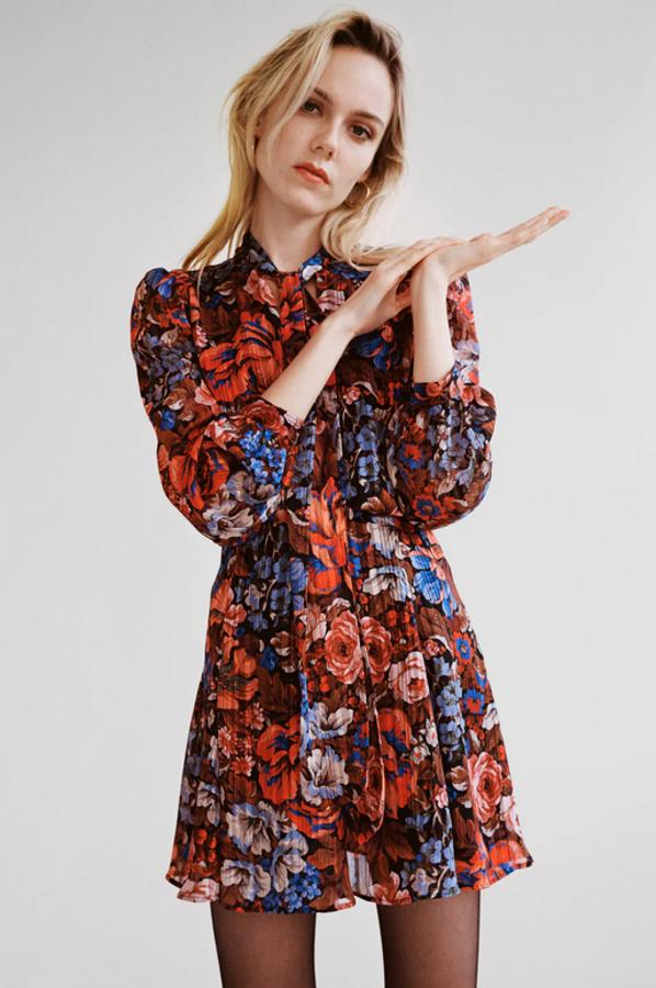 Cuello subido con lazo para este vestido en tonos azules y rojos con escote de pico y mangas largas acabadas en puño con botón. Con detalles de hilo metalizados y cintura elástica, cuesta 49,95 euros y está disponible entre las tallas XS y XL.