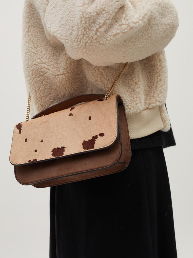 Esta bandolera de piel en tonos marrones con cierre de solapa en estampado animal, asa de mano a tono y asa de hombro dorada de cadena costaba 27,99 euros y ahora podemos comprarla por 22,39 euros.