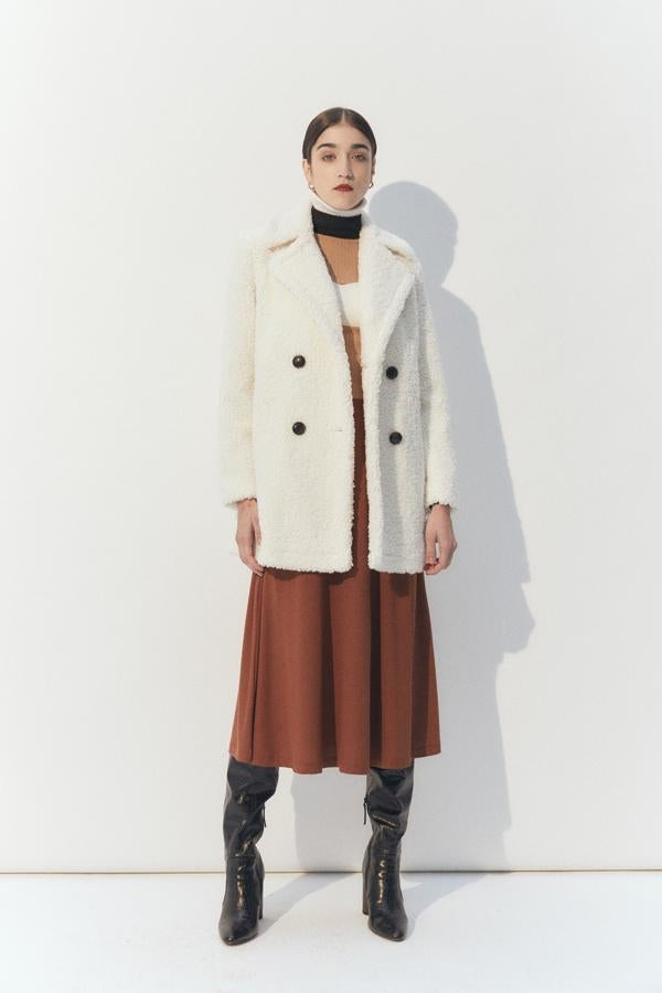 En color crudo, de pelo rizado y con cuello de solapas con muesca, este abrigo midi con cierre frontal de botones a contraste costaba 49,99 euros y ahora podemos comprarlo en las tallas M y L por 39,99 euros.