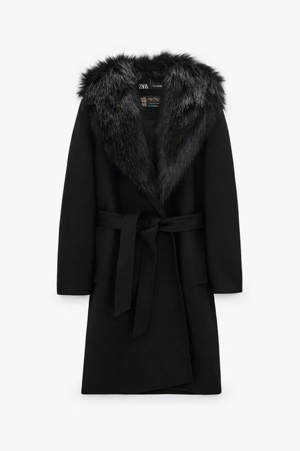 Con cuello de solapa en efecto pelo desmontable, este abrigo negro con bolsillos de vivo en delantero y bajo con abertura en la espalda tiene cierre de cinturón a tono y de 99,95 euros ha pasado a 59,97 euros.