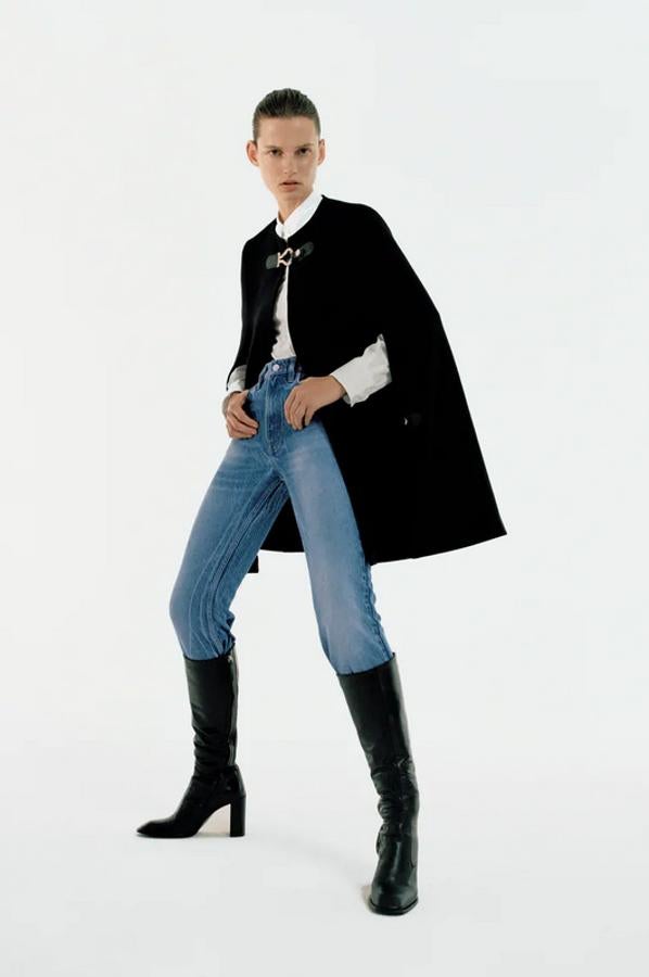 Con cuello redondo y cierre de trabilla combinada en delantero, esta capa negra costa 89,95 euros y ahora podemos comprarla por 53,97 euros.