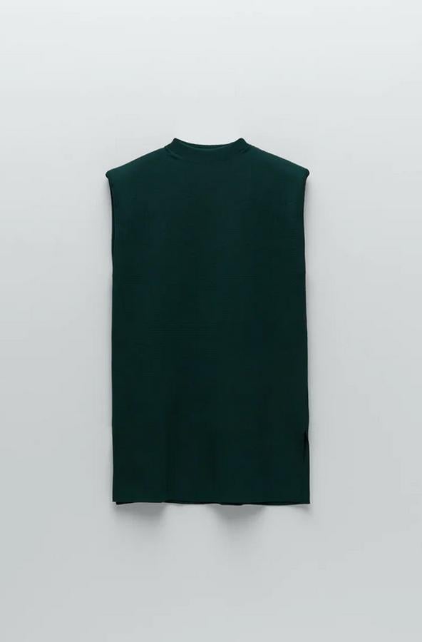 Con cuello subido y mangas sisa con hombreras, este top en verde botella con bajo acabado con aberturas laterales costaba 25,95 euros y ahora está por 15,57 euros.