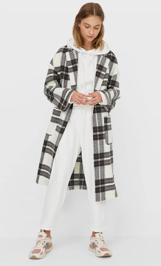 En color vainilla con cuadros, este abrigo abierto de punto cuenta con bolsillos delanteros y tiene un precio de 39,99 euros. Es de Stradivarius.