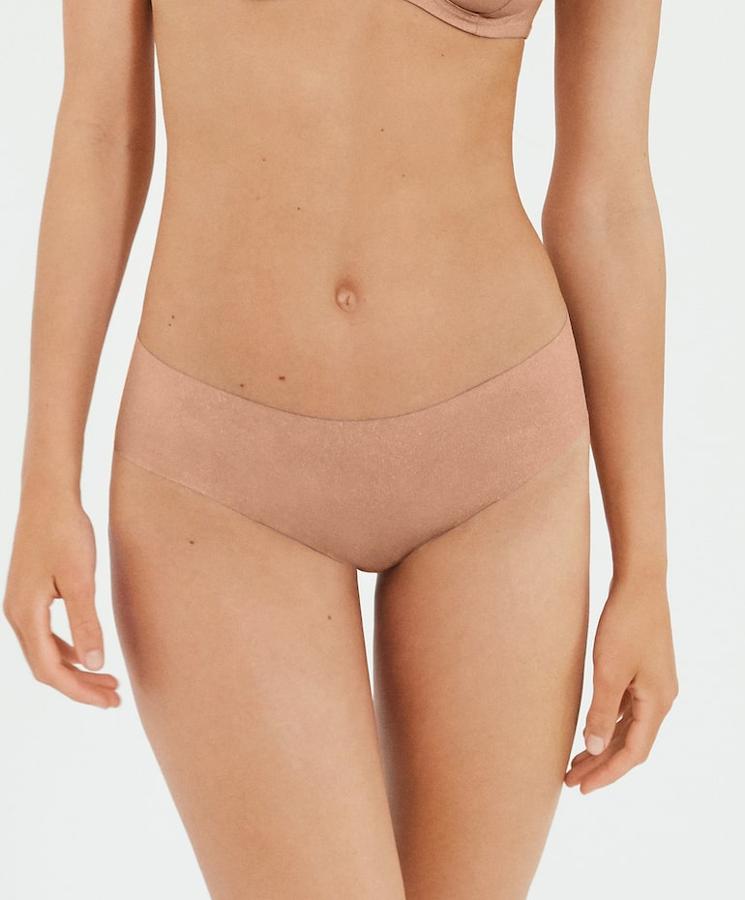 En tejido de microfibra liso y brillante en color cobre, esta braguita con acabados cortados a láser y cintura elástica resulta invisible bajo la ropa. Es de Oysho y tiene un precio de 5,99 euros.