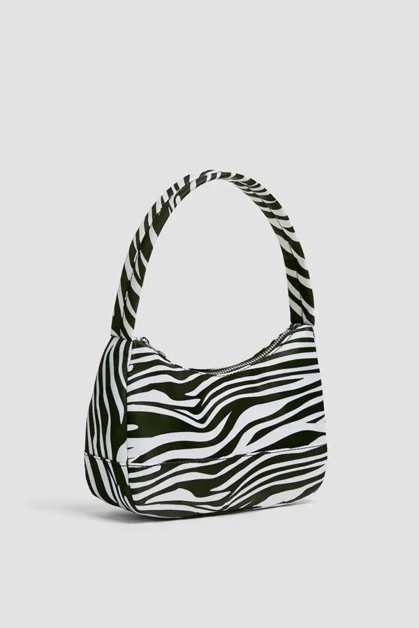 Este bolso mini con estampado de cebra está disponible en varios colores. Con cierre mediante cremallera, cuenta con forro interior con bolsillo y tiene un precio de 15,99 euros. Es de Pull & Bear.