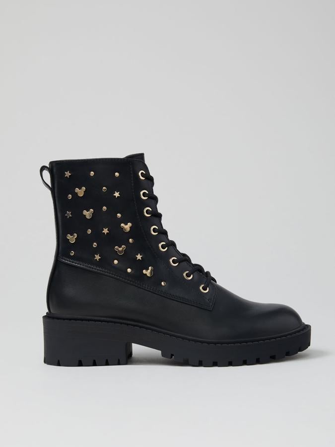 En color negro y con suela track, este botín con piezas doradas decorativas con firma de Mickey en los laterales cuenta con cierre mediante cremallera lateral y cordones. Tiene un precio de 35,99 euros.