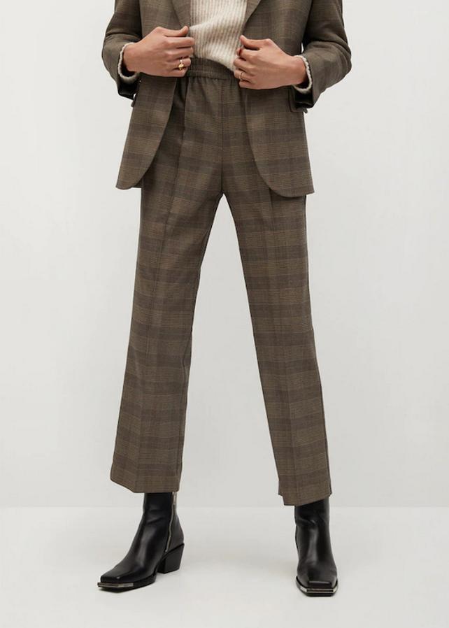 Diseño recto y tiro medio para este pantalón de Mango de cintura elástica con bolsillos laterales en beige oscuro con cuadros negros. Cuesta 29,99 euros y está disponible entre las tallas XS y XL.