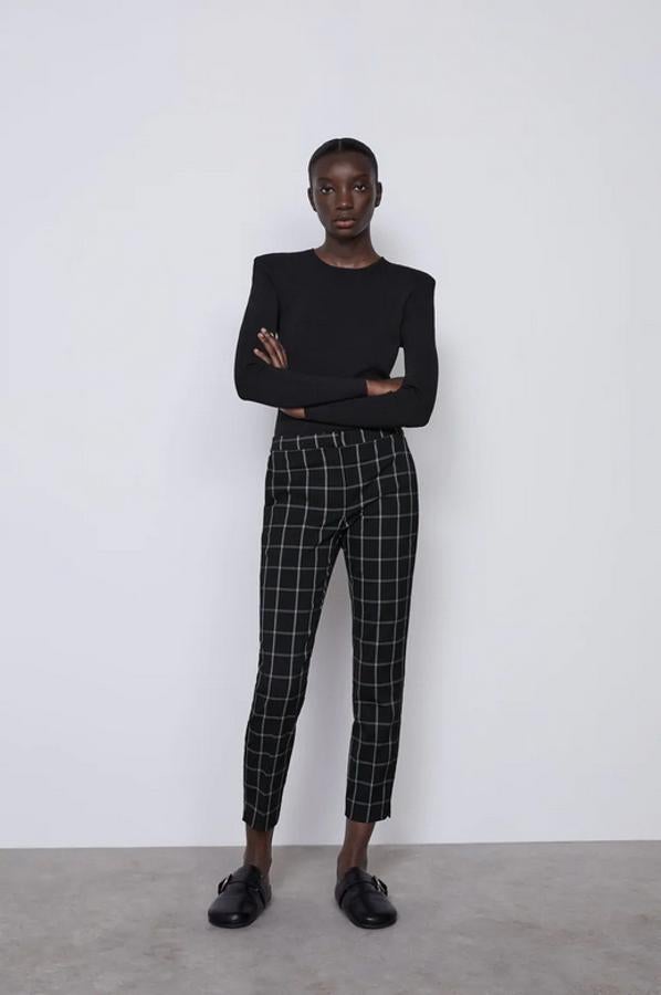 Este pantalón de pitillo de tiro medio con cintura elástica en la espalda es de Zara y viene con bolsillos frontales y está confeccionado con al menos un 25% de poliéster reciclado. En negro con cuadros blancos, cuesta 19,95 euros y solo queda en la talla L.