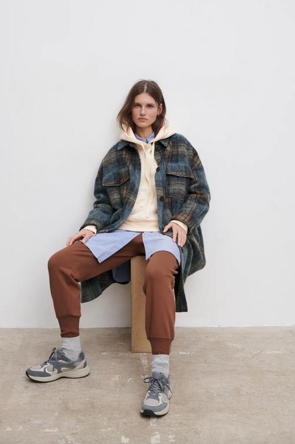 Confeccionada con tejido en mezcla de lana, esta sobrecamisa larga con cuello solapa, bolsillos laterales ocultos y bolsillos frontales de plastrón con solapa en tonos azules, beige y rojizos está disponible entre las tallas XS y XL por 59,95 euros.