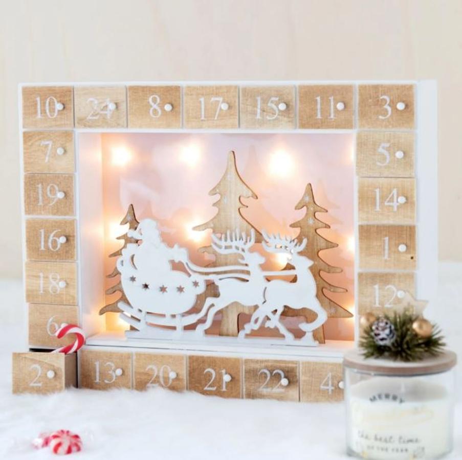 En Maisons du Monde encontramos este bonito calendario de Adviento de madera con cajoncitos numerados, siluetas navideñas y luces. Cuesta 39.99 euros.