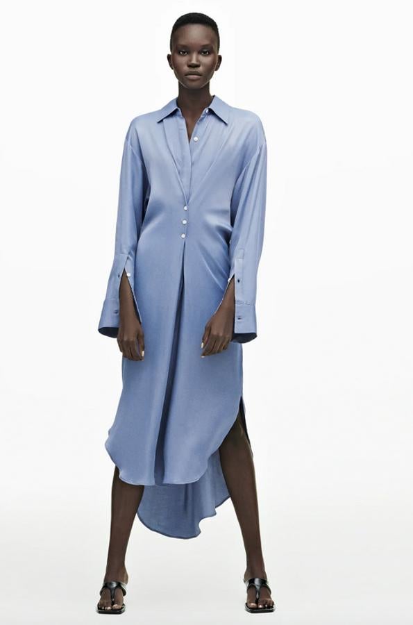Cuello solapa y escote de pico con manga larga acabada en puño para este vestido camisero de Zara en azul claro que tiene bajo asimétrico y detalle de pliegue con botones en delantero. Confeccionado en viscosa sostenible al 50%, cuesta 39,95 euros y está disponible entre las tallas XS y XL.