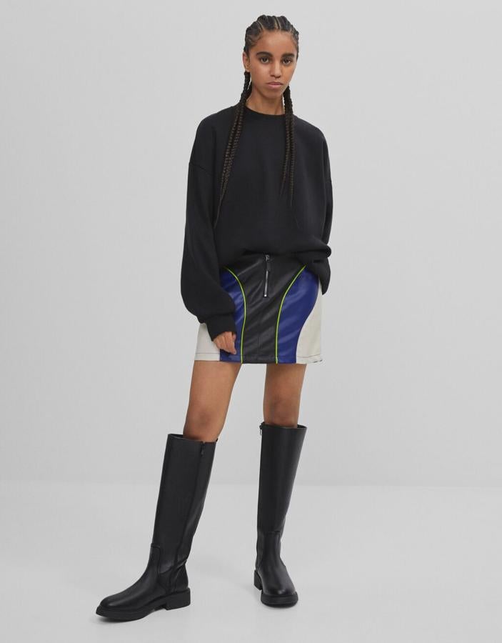 En efecto piel y diseño en azul, blanco y negro, esta minifalda de Bershka con cierre frontal de cremallera y botón ha pasado de 22,99 euros a 13,79 euros y podemos encontrarla entre las tallas XS y L.