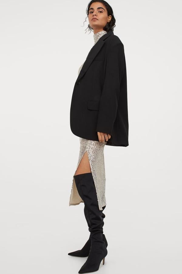 Falda midi confeccionada con un tejido malla bordada de lentejuelas. Lleva el talle alto y cierra con cremallera oculta y un botón en un lateral. Atención a la pronunciada abertura delantera: la fada incluye una enagua en punto de poliéster reciclado (H&M, 29,99 euros).