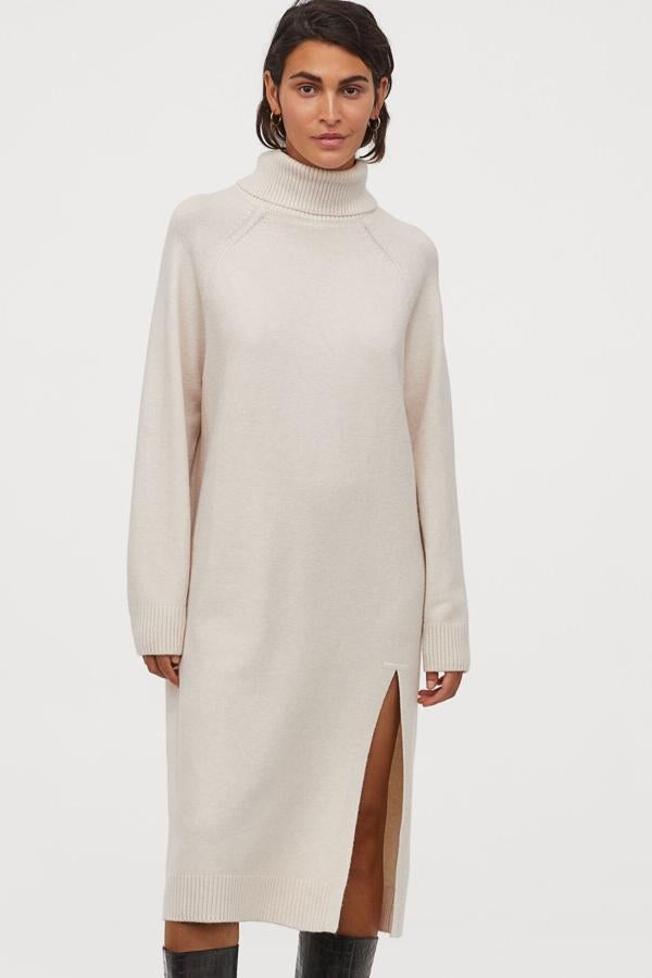 En color beige claro, este vestido midi en punto suave con cuello alto de canalé cuenta con abertura en la parte delantera y tiene un precio de 34,99 euros.