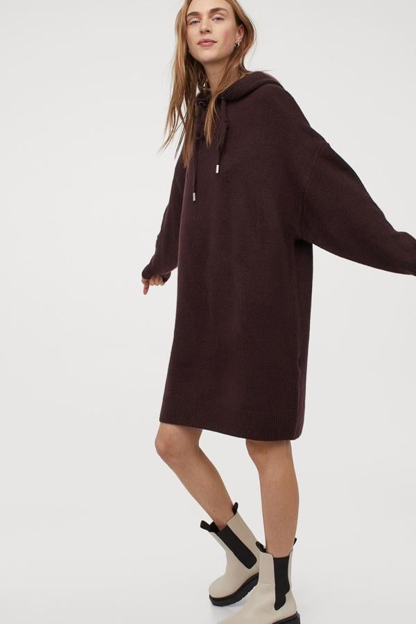 Este vestido corto en punto suave con lana de color burdeos cuenta con capucha con cordón de ajuste y hombros caídos. Tiene un precio de 39,99 euros.