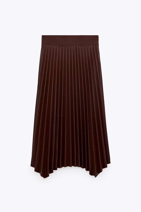Con efecto piel en color burdeos, esta falda plisada con bajo asimétrico cuenta con cremallera oculta en el lateral y tiene un precio de 29,95 euros. Es de Zara.