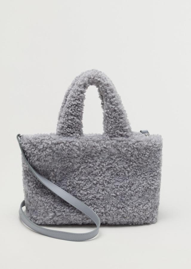 Confeccionado en tejido de efecto pelo de color gris, este bolso cuenta con dos asas, una corta y una larga desmontable y tiene un precio de 29,99 euros.