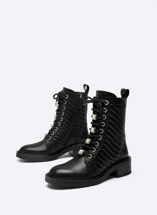 Con diseño acolchado en la caña, aplique de perlas en la cordonera extraíbles y brillantes en los ojales, estos botines de piel de vacuno de Uterqüe vienen con cremallera interior de la caña. Podemos encontrarlos entre los números 36 y 42 por 159 euros.