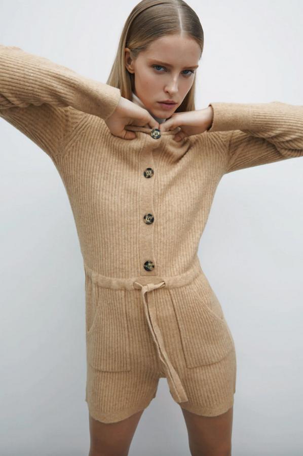 Este mono de pernera corta, con capucha, mangas largas y bolsillos delanteros de plastrón en beige oscuro es de Zara y tiene la cintura ajustable con cordón. Podemos encontrarlo en las tallas S, M y L por 29,95 euros.