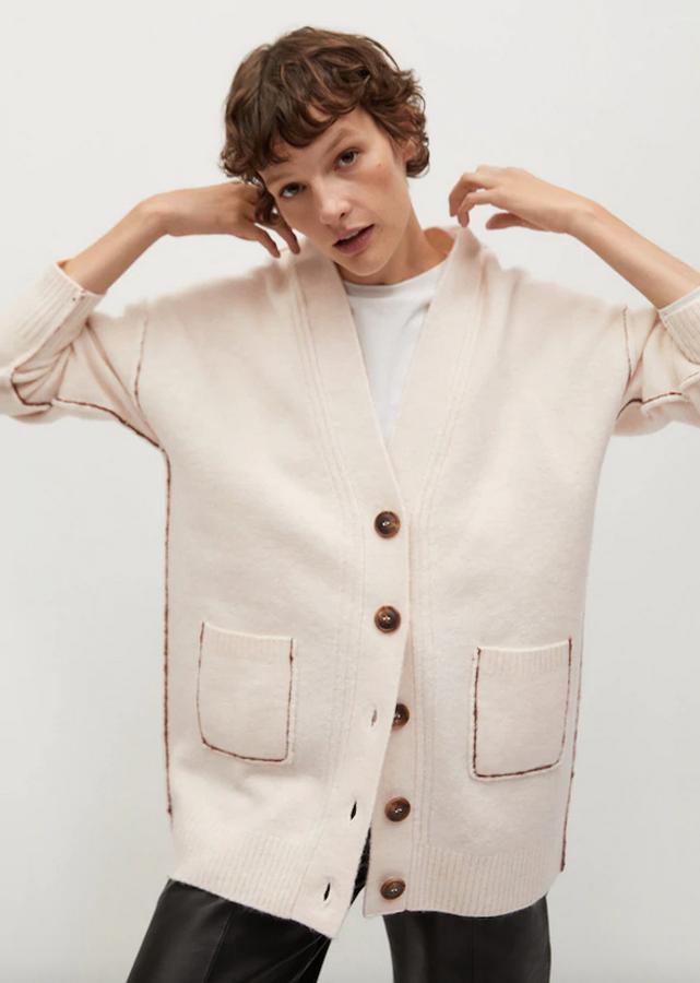 Con cuello de pico y costura de hombro caído este bonito cárdigan en color crudo y diseño oversize se merecía colarse en esta galería por sus originales costuras vistas en los bolsillos y los laterales. Con terminaciones en canalé y cierre de botones de carey en el frontal a contraste, es de Mango, cuesta 29,99 euros y está disponible en las tallas S, M y L.