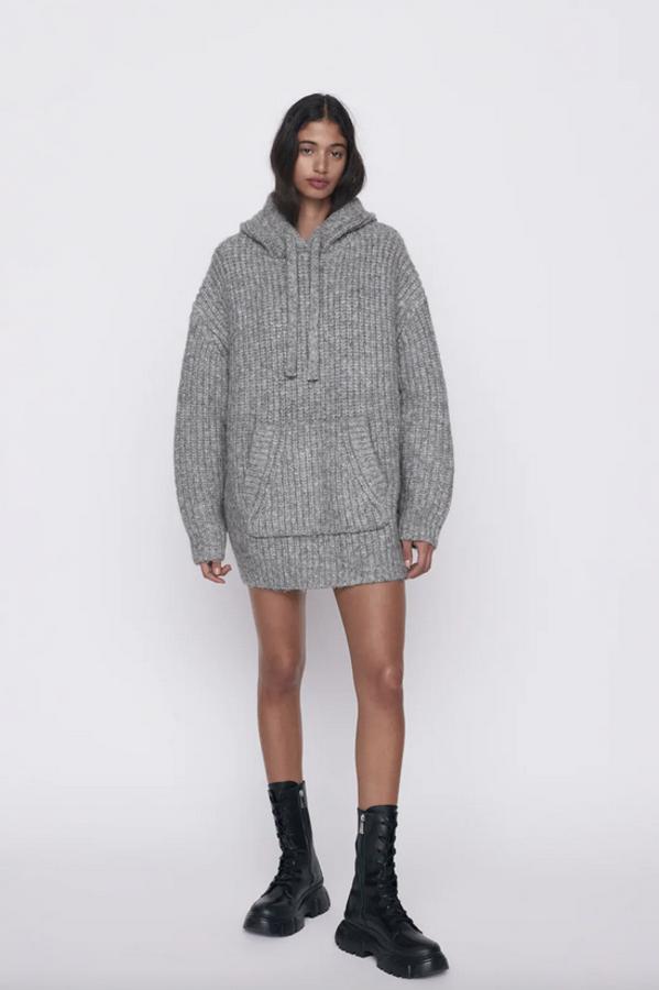 De cuello subido con capucha ajustable con cordón y mangas largas, este bonito jersey oversize gris en color gris viene con bolsillo delantero de plastrón tipo canguro. Cuesta 39,95 euros y solo queda en la talla M-L.