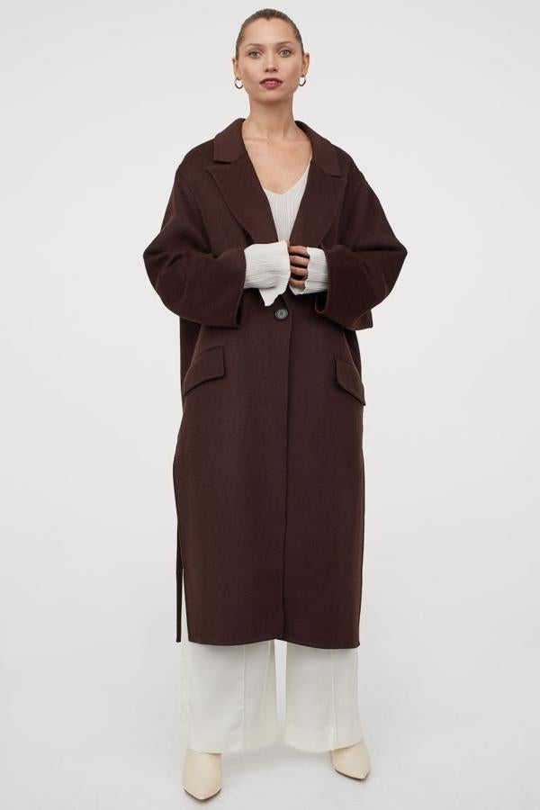 Disponible en marrón oscuro y en beige claro, este abrigo oversize en mezcla de lana de fieltro es de H&M y viene con botonadura sencilla, solapas de muesca finas y bolsillos delanteros con solapa. Con aberturas laterales pronunciadas podemos encontrarlo entre las tallas XS y XL por 99 euros.
