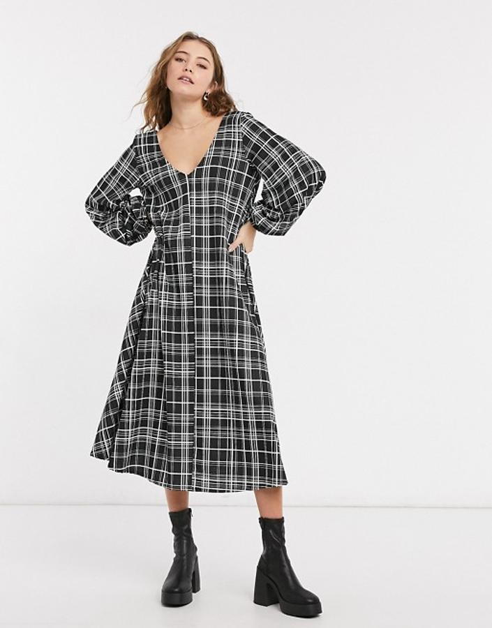 Fondo negro con estampado de cuadros blanco para este vestido midi de diseño holgado escote de pico, y mangas largas acabadas en puño elástico. Es de Asos Design, cuesta 41,99 euros y podemos encontrarlo entre las tallas 32 y 46.
