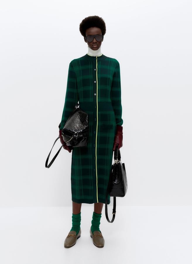 Confeccionado en punto jacquard, este vestido en tonos verdes y azules de Uterqüe viene con cuello perkins, cintura acanalada, detalle de vivo a contraste y cierre frontal de botones. Disponible en las tallas S, M y L y cuesta 99 euros.