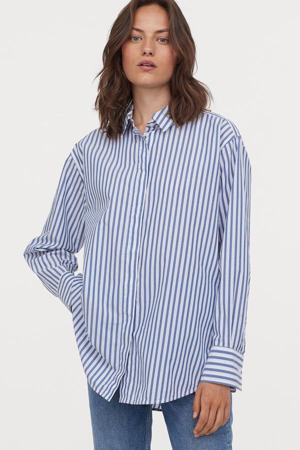 Esta camisa blanca con rayas azules y diseño oversize está confeccionada en 100% algodón y cuenta con bajo redondeado. Es de H&M y tiene un precio de 19,99 euros.