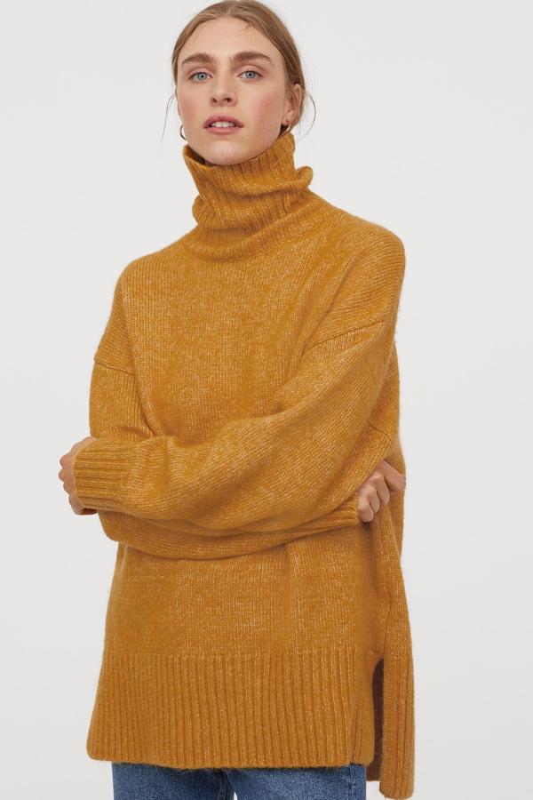 Este jersey maxi de H&M en color amarillo está también disponible en negro y beige. Con ribete de canalé en puños y bajo y aberturas laterales, tiene un precio de 29,99 euros.