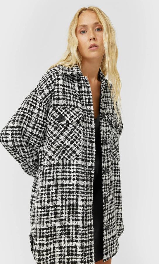 Esta sobrecamisa amplia de cuadros en blanco y negro con bolsillos laterales ocultos es la costura y cierre frontal de botones es de Stradivarius y tiene un precio de 35,99 euros.