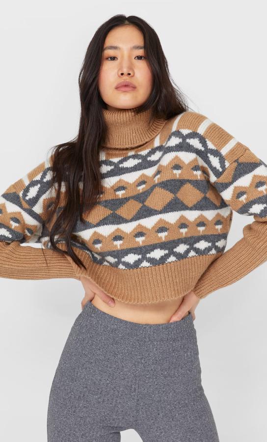 En color tostado, gris y crudo, este jersey estampado ancho con cuello alto tiene un precio de 25,99 euros.
