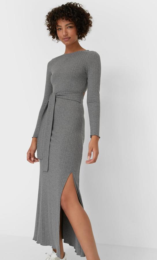 Disponible en gris, camel o negro, este vestido midi de punto con cuello redondo y detalle de lazo en la cintura cuenta con abertura en la espalda y tiene un precio de 19,99 euros. Es de Stradivarius.