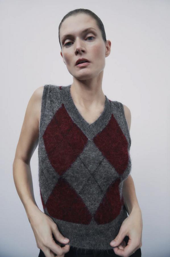 Fondo gris con estampado de rombos en tonos granates para este chaleco de punto que pertenece a la edición limitada de Zara confeccionado con tejido en mezcla de lana. Con manga sisa y escote de pico viene con detalle de espalda combinada con aplicación de trabillas. Solo queda en las tallas S y M y cuesta 29,95 euros.