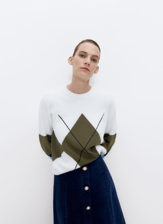 Un rombo en caqui para este jersey blanco de Uterqüe con espalda lisa, mangas listadas combinando dos materiales y acabados en rib. Cuesta 89 euros y está disponible en las tallas M y L.