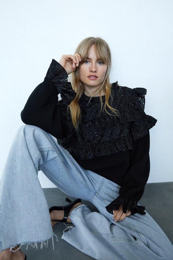 Con cuello redondo y manga larga, este jersey negro de Zara con detalle de tejido combinado con bordados perforados y aplicación de volantes en la pechera y los hombros está disponible en las tallas S, M y L por 29,95 euros.