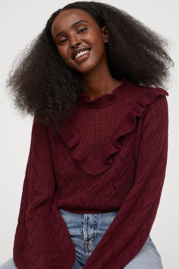 En punto de encaje suave con volante en el escote y ribete de volante en V delante, este jersey en color vino de H&M viene con puños y bajo en punto de canalé. Solo queda en la talla S y cuesta 29,99 euros.