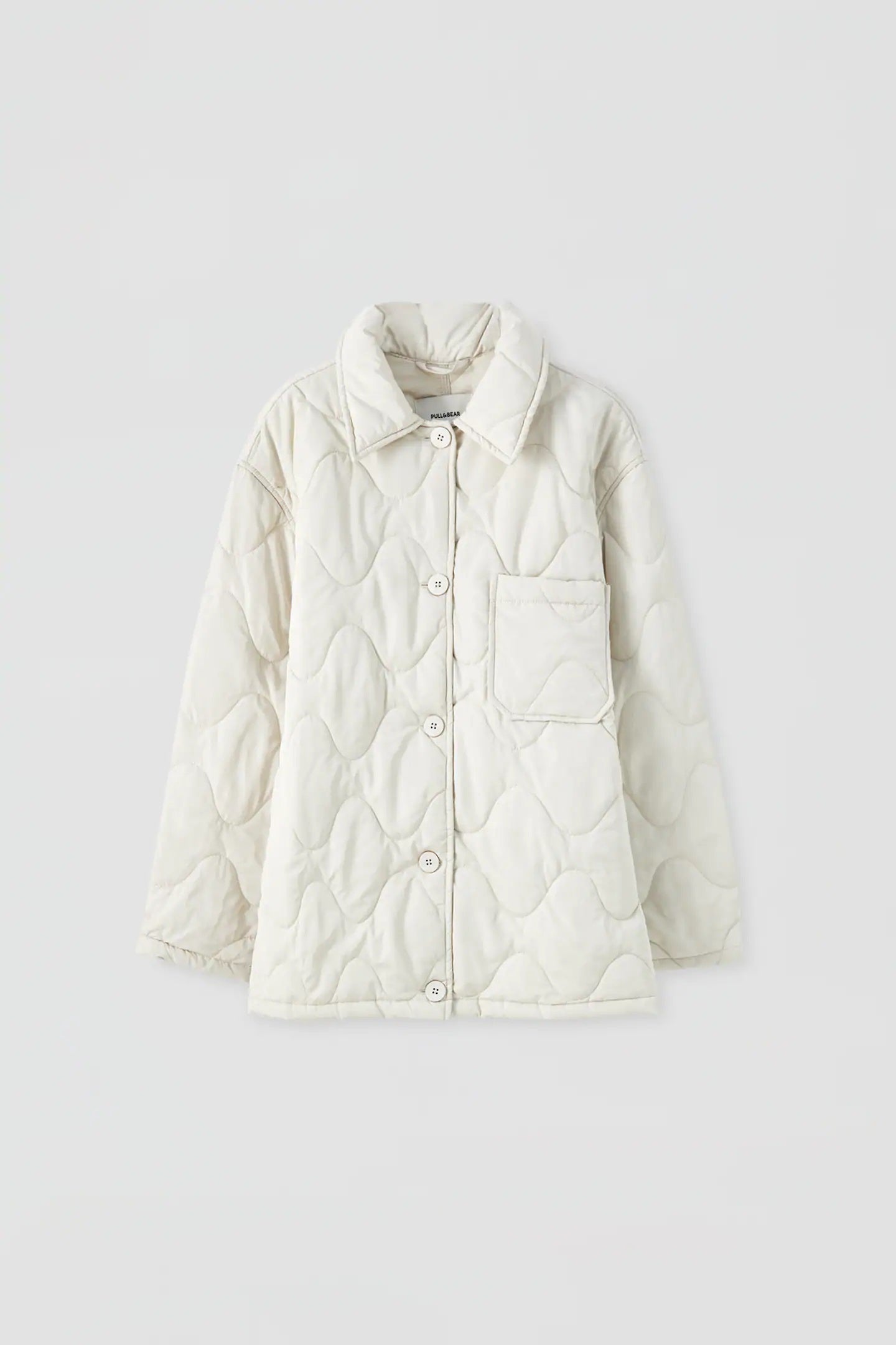 Abrigo acolchado de Pull&Bear en blanco crudo con cierre de botones. Perfecto para combinar con vaqueros, con pantalones de punto, de traje, de efecto piel, estampados... (25,99 euros).