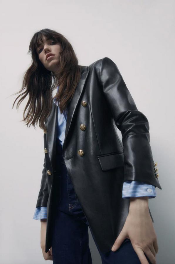 Con cierre frontal cruzado con botones dorados, esta blazer en efecto piel de Zara viene con mangas largas con hombros marcados, bolsillos de solapa en delantero y bajo con abertura en la espalda. Tiene un precio de 59,95 euros y está disponible entre las tallas XS y XXL.