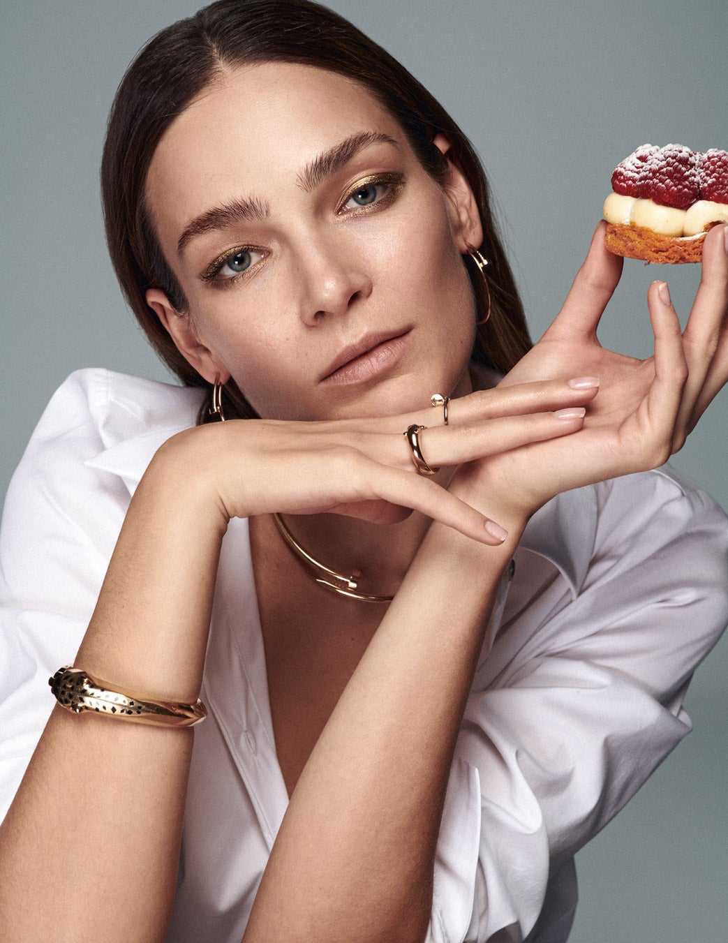 Camisa de El Corte Inglés Woman Limited. Collar Juste un Clou de oro amarillo; pendientes Juste un Clou de oro rosa; pulsera Panthère de oro amarillo con granates, tsavoritas y ónix; y sortija Juste un Clou de oro amarillo, todo de Cartier; y sortija Serpenti de Bvlgari. Pastel de Habaziro by Pablo Morales.