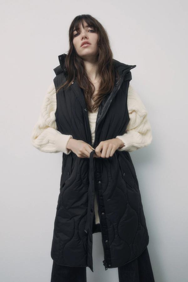 En color negro, este chaleco acolchado con tejido repelente al agua y capucha desmontable con cremallera cuenta con bolsillos laterales con solapa y cierre frontal con cremallera. Tiene un precio de 49,95 euros.