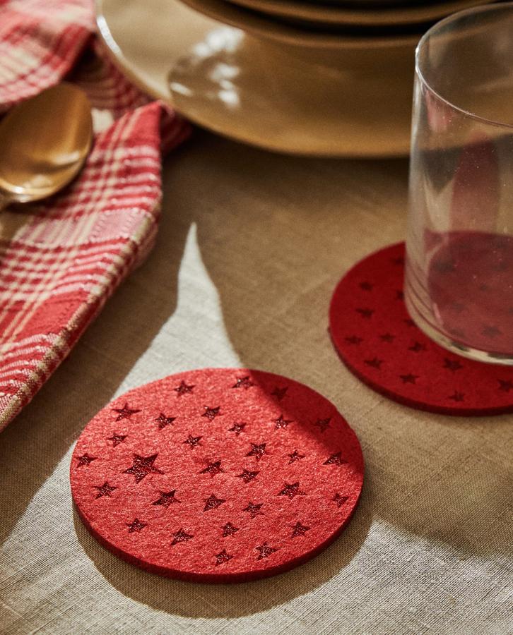Hechos en fieltro de color rojo, estos posavasos redondos con estrellas se venden en pack de seis unidades y tienen un precio de 5,99 euros.