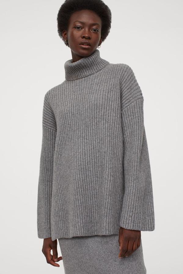 En punto fino suave de canalé con lana en la trama, este jersey en gris claro de corte relajado viene con cuello alto doble, hombros marcadamente caídos y bajo con aberturas laterales. Confeccionado con poliéster reciclado, tiene un precio de 39,99 euros y está disponible entre las tallas XS y XXL.