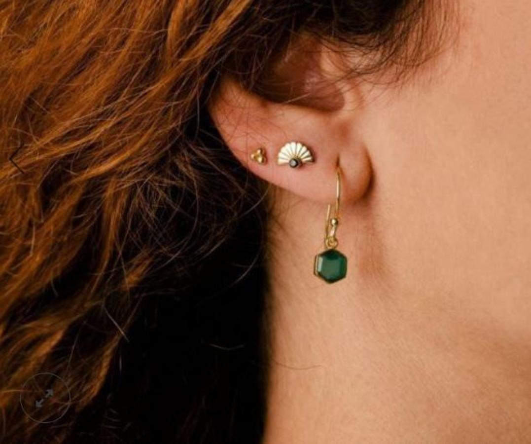 Sencillos y minimalistas. Así son los Attrium pendientes priene de Acus: tres bolitas doradas que aportan un toque perfecto de luz a la cara por solo 18,90 euros.