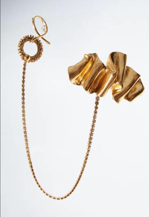 Broche metálico con doble cadena, aplicación de brillos y perlas de Zara. Perfecto para las que buscan un toque de distinción. Precio: 12,95 euros.