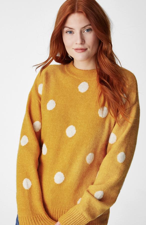 En color amarillo con lunares grandes blancos, este jersey oversize de lana con remates de canalé tiene un precio de 19,99 euros.
