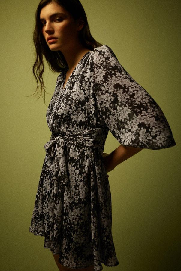 Con escote de pico y manga larga, este vestido negro con estampado floral en color blanco viene con detalle de cinturón combinado a tono y de 39,95 euros ha pasado a costar 19,99 euros. Está disponible en las tallas XS y L en Zara.