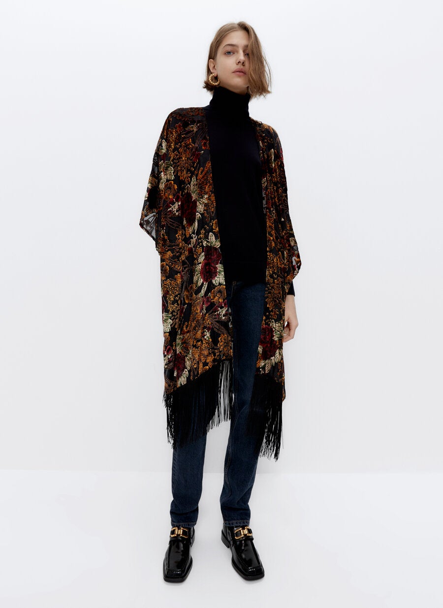 Chaqueta tipo kimono de terciopelo con estampado de flores y flecos en el bajo de la nueva colección de Uterqüe. Una prenda única para armarios únicos. (99 euros).
